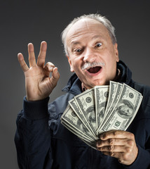 Senior gentleman holding a stack of money