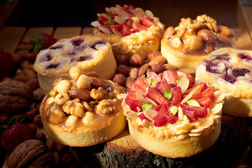 Mini tarts cupcakes with strawberries, walnuts, almond, nuts and blueberries. Close up