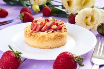 Strawberry mini tart on purple wooden background