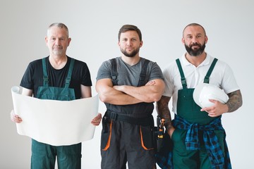 Group of three builders preparing for remodeling of the apartment