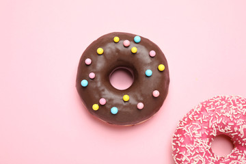 Delicious glazed donuts on pink background, flat lay