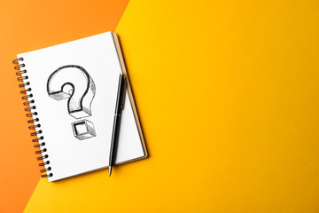 Notebook with question mark and pen on color background, top view. Space for text