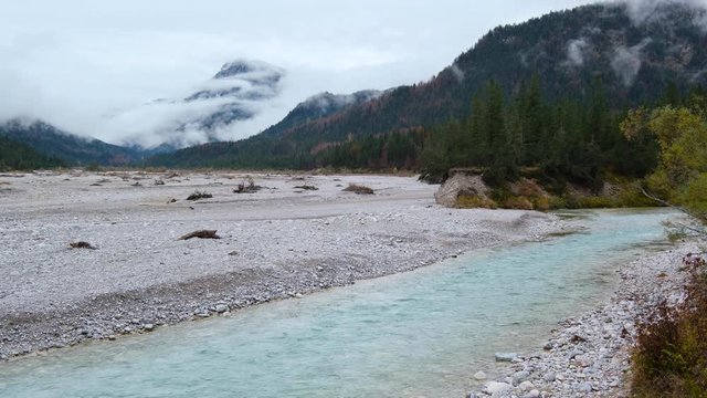 Autumn overcast day on Karwendel Bavarian Prealps and Isar river flow, Germany. Picturesque traveling, seasonal and nature beauty concept scene.