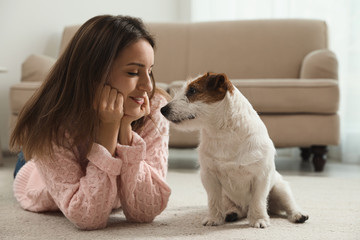 Young woman with her cute Jack Russell Terrier at home. Lovely pet