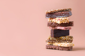 Different Energy protein bars and oatmeal bars on light brown chocolate background. Set of energy,...