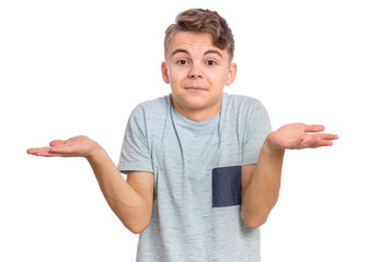 Portrait of teen boy showing helpless gesture with arm and hands - I do not know. Young teenager isolated on white background. Shrugging, confused child making helpless sign and looking at camera. - 330982286