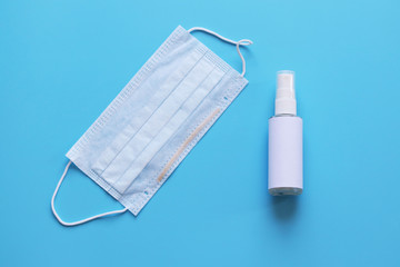 antiseptic and protective disposable mask on a blue background. Hygiene concept. prevent the spread...