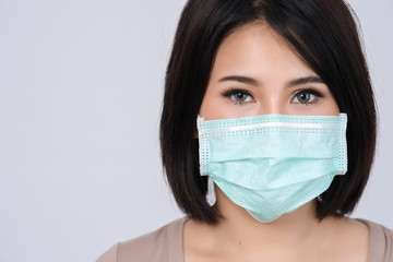 Close up asian woman in mask on  white background  protection against virus, infection, air pollution and coronavirus in China. Free from copy space.