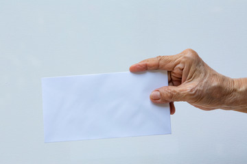 Senior woman's right hand holding white envelope or bride isolated on white background, Close up and macro shot, Business concept