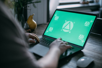 Woman working on a laptop at home, close-up of a laptop on the table and hands