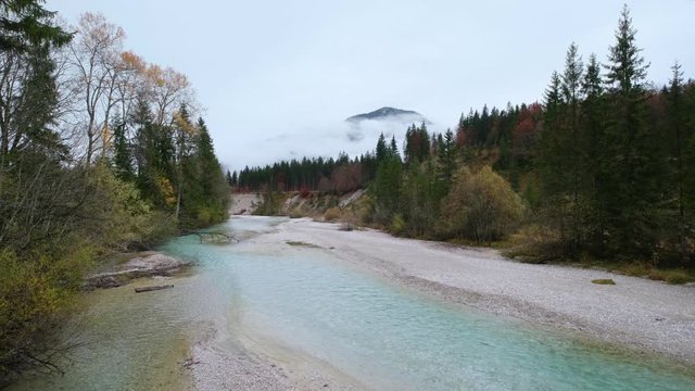 Autumn overcast day on Karwendel Bavarian Prealps and Isar river flow, Germany. Picturesque traveling, seasonal and nature beauty concept scene.