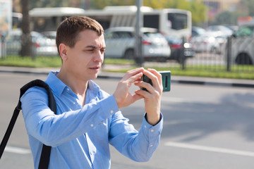 A man photographs himself on the phone on a city street. Caucasian male tourist makes selfie on smartphone arab country