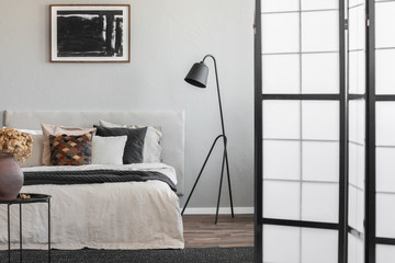 Elegant bedroom interior with king size bed in fashionable apartment, real photo