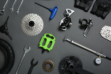 Set of different bicycle tools and parts on grey background, flat lay