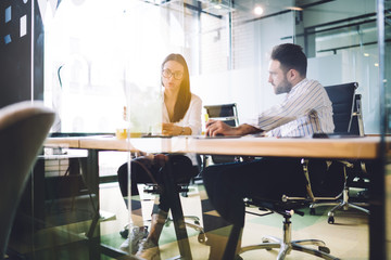 Adult male and female employees sitting at meeting room in company