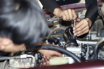 Image of a mechanic checking and fixing the engine