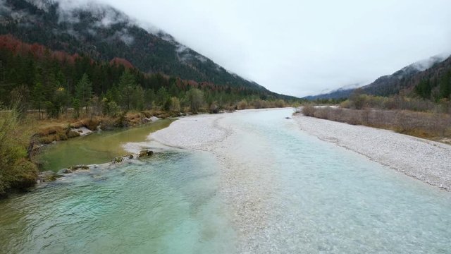 Autumn overcast day on Karwendel Bavarian Prealps and Isar river flow, Germany. Picturesque traveling, seasonal and nature beauty concept scene.