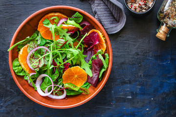 healthy salad tangerines citrus, lettuce, arugula and other herbs. Menu concept food background, keto or paleo diet. top view. copy space for text