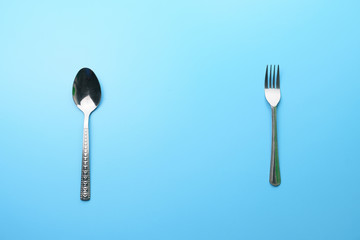 dieting and health care concept. top view of fork and spoon on blue dine table. flat lay. free copy space for your text