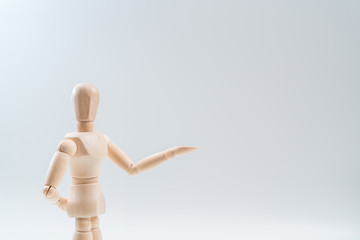 Wooden dummy proudly presents some invisible thing, isolated on white background, copy space for your object or text