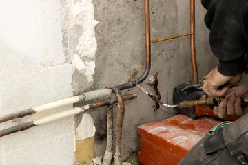Pipework. Plumbing contractor works sweating the joints on the copper pipe domestic water system