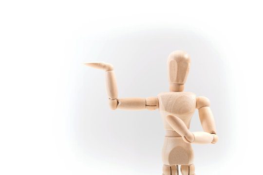 Wooden dummy proudly presents some invisible thing, isolated on white background, copy space for your object or text