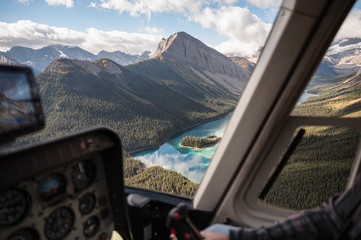 Inside of helicopter flying on rocky mountains with colorful lake