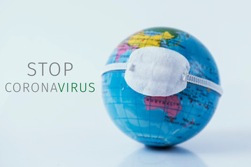 world globe with a mask and text stop coronavirus.