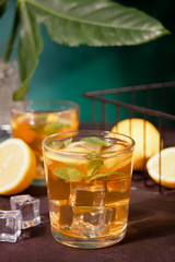 Two glasses of cold refreshment tea with ice and lemon fruit.