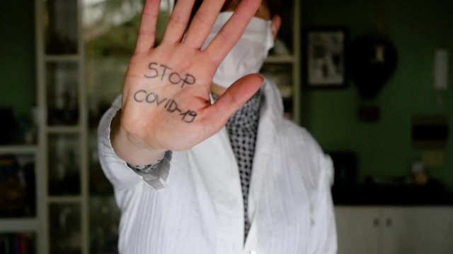 Woman with one hand written Stop covid-19
