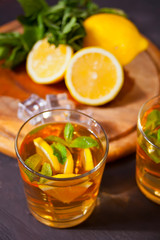 Two glasses of cold refreshment tea with ice and lemon fruit.