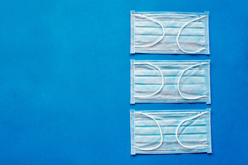 three medical mask isolated on blue background, Corona protection