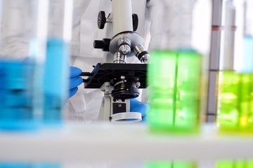 Researchers are sending microscopes to find a cure for the virus. There is a test tube blurred in the foreground. Research concepts in communicable disease prevention and control laboratory