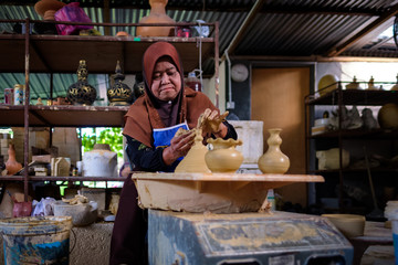 Local woman demonstrates on making traditional clay jar called "Labu Sayong" or Essence Jar of Sayong in Kuala Kangsar, Perak, Malaysia.