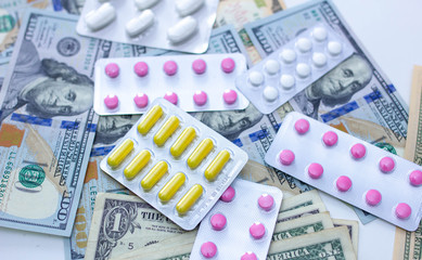 medicines and pills with dollars money, pharmaceutical drugs price hike concept.