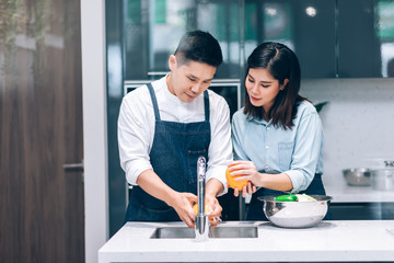 Happpy Asian Couple Cooking Together and Washing Vegetables in the Kitchen at Home - Hobby Lifestyle Concept