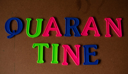 'QUARANTINE' written on a brown wooden background 