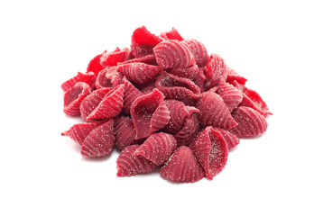 Raw colored conchiglie pasta with beetroot isolated on a white background