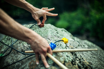 Close up selective focus shot of a spiritual man using modern implements to create music from a large boulder in nature, vibrational healing sounds with copy space.