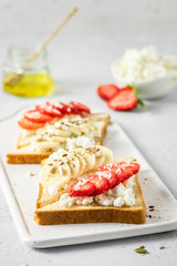Strawberry banana goat cheese toasts. Selective focus, copy space.