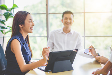 Business woman presenting and discussing financial data and analyzing report graph by digital tablet at office. Teamwork meeting and partnership conference working concept.