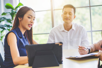 Business woman presenting and discussing financial data and analyzing report graph by digital tablet at office. Teamwork meeting and partnership conference working concept.