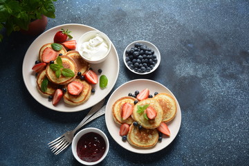 Sweet pancakes served with fresh blueberries , mint, strawberries,organic agave syrup. Healthy breakfast concept