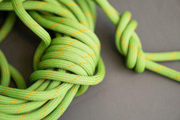 coiled green climbing rope with knot