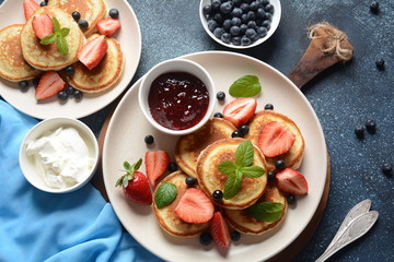 Sweet pancakes served with fresh blueberries , mint, strawberries,organic agave syrup. Healthy breakfast concept