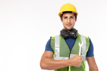 Portrait young repairman holding wrench. isolated white background, copy space. Hard working worker or labor guy wearing safety helmet, safety vest, welcome smile. ready for fix or repair things