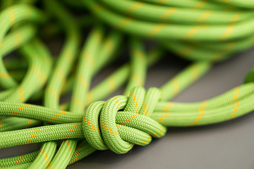 green coiled climbing rope tied with figure eight knot