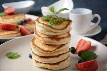 Sweet pancakes served with fresh blueberries , mint, strawberries,organic agave syrup. Healthy breakfast concept