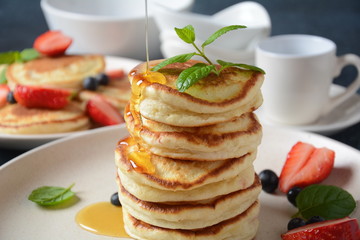 Sweet pancakes served with fresh blueberries , mint, strawberries,organic agave syrup. Healthy breakfast concept