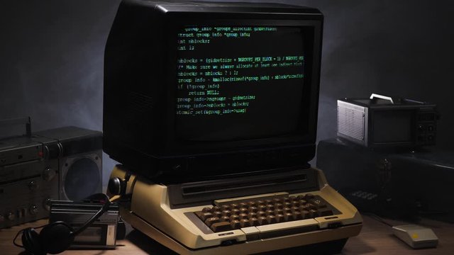 Black screen of a vintage style computer from 70s 80s  filling up with green coding lines. Old concept
